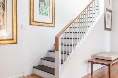 The designers created a more open and inviting landing to the lower level of the home. A custom railing on the existing stairs allows light from the main floor to drift downstairs. Powder-coated metal pairs with a white oak handrail. Indoor Stair Railing, Wood Railings For Stairs, Metal Stair Railing, Oak Handrail, Interior Stair Railing, Modern Stair Railing, White Staircase, Open Trap, White Stairs