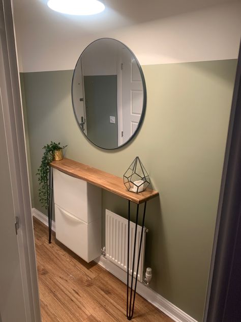 Narrow Hallway, Hairpin leg radiator cover, Round Mirror, Newbuild Small Living Room Ideas Olive Green, Green Wall Entrance, Pastel Green Hallway, Olive Hallway Ideas, Sage Green Hallway Ideas Entrance Halls, Olive Green Hallway Ideas, Olive Green Panelling, Overtly Olive Kitchen, Feature Wall Hallway