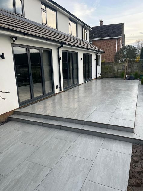 A modern patio while using a traditional look paver. This porcelain paver has realistic characteristics to natural stone. This patio was completed by Dunnington Landscapes Ltd using Aged Kandla Grey porcelain, this paving is available in 600x600mm and 600x900mm. 📞Call our team on 01977 782240 💻Visit the product on our website https://rflandscapeproducts.co.uk/product/aged-kandla-grey-2cm-porcelain-paving/ Details ✔️ Product : Aged Kandla Grey Format - 600x900mm Credit - Dunnington Lands... Patio Paving Ideas Inspiration, Back Garden Patio Ideas, Kandla Grey Porcelain Patio, Grey Porcelain Paving, Grey Patio Ideas, Grey Porcelain Patio, Grey Patio Paving, Patio Stones Backyard, Exterior Tiles Floors