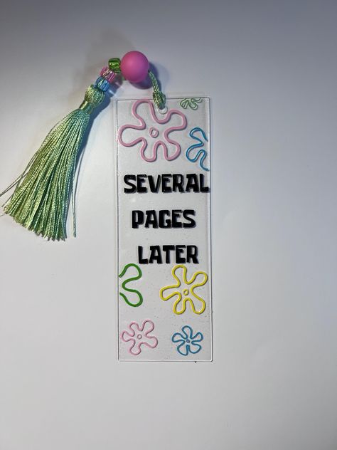 Acrylic bookmark saying "several pages later". Bookmark may come with a green, pink, or blue tassel depending on stock. Diy Bookmarks To Sell, Diy Acrylic Bookmarks Cricut, Cute Handmade Bookmarks, Bookmark Ideas Handmade, Cricut Acrylic Projects, Book Mark Designs, Book Mark Art, Bookmark Sayings, Acrylic Bookmark Ideas