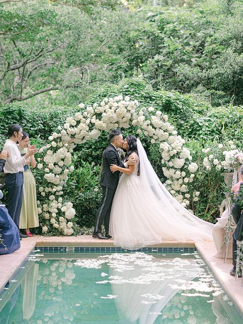 Bride and groom first kiss at Meadowlark 1939 by Laura Watson Photography Pool Wedding Ideas, Poolside Wedding Ceremony, Engagement Setup, Meadowlark 1939, Wedding Pool Party Decorations, Backyard Wedding Pool, White Floral Arch, Pool Wedding Decorations, Wedding Video Inspiration