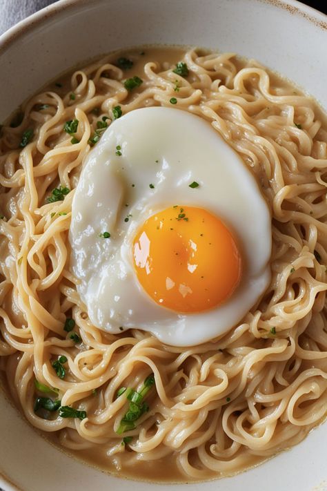 Creamy Ramen Noodles With Egg Recipe

Ingredients

- 2 packs of instant ramen noodles
- 2 cups water
- 1/2 cup heavy cream
- 2 large eggs
- 1 tablespoon soy sauce
- 1 green onion, chopped

Instructions

- In a pot, bring 2 cups of water to a boil and add the instant ramen noodles. Cook for 3-4 minutes until tender. 
- Stir in heavy cream and soy sauce, then create a small well in the noodles and crack the eggs into it. Cover and let cook for an additional 2-3 minutes. 
- Full Recipe on... Egg And Ramen Noodles, Roman Noodles With Egg, Ramen With Fried Egg, Ramen With Egg Recipes, Creamy Ramen Noodles, Ramen Noodles With Egg, Ramen With Egg, Egg In Ramen Noodles, Roman Noodles