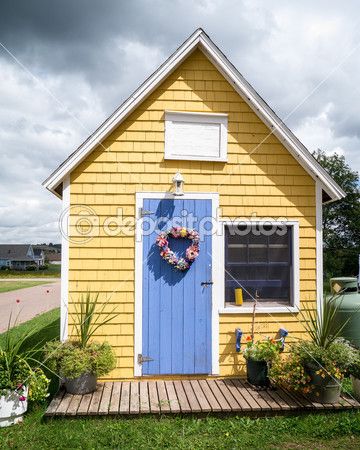 There’s something about a little yellow house that just feels like home.  Take a peek… Periwinkle Exterior House Colors, Yellow House Blue Door, Periwinkle Door, Yellow Shed, Yellow House Exterior, Pei Canada, Yellow Cottage, Shed Colours, Pintura Exterior