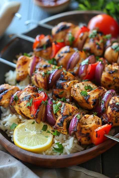 Grilled chicken kebabs with red peppers and onions served on a bed of rice with a lemon slice garnish. Mediterranean Barbecue, Chicken Mediterranean Recipes, Mediterranean Skewers, Simple Mediterranean Recipes, Mediterranean Diet Chicken Recipes, Chicken Skewers In Oven, Mediterranean Chicken Skewers, Mediterranean Chicken Kabobs, Chicken On Skewers