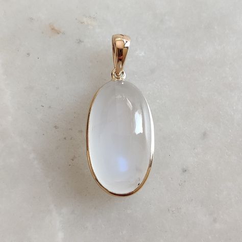 This stunning pendant is set in 14k Solid Yellow Gold with Natural Rainbow Moonstone with utmost precision. It is a unique gemstone pendant for nearly every occasion and is completely hassle-free jewelry. ITEM DETAILS: * GEM: Rainbow Moonstone * GEM Size: 11X18mm * GEM Shape: Oval * Gem Weight: 12.86 carats * Gold Purity: 14KT  * Gold Weight: 0.62 gram * Total Weight of the Pendant: 3.19 gram The Gold purity is guaranteed and it comes with an authentic 14KT gold hallmark. Since my items are handmade, they are absolutely nickel and lead free. CUSTOMIZATION: * Gemstone customization is available and it can be substituted with a gem of your choice. Kindly message me for the same. PACKAGING * The Pendant comes with layers of safe and secure wrapping along with a Free handmade jewelry box with Afro Jewelry, Ethereal Jewelry, Rainbow Moonstone Necklace, Handmade Jewelry Box, Gemstone Pendant Necklace, Gem Necklace, Blue Moonstone, Jewelry Christmas, June Birthstone