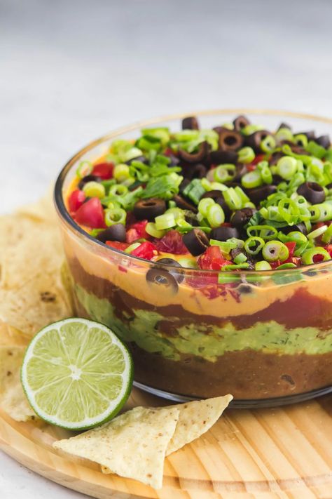 This Vegan Seven Layer Dip is made of layers of Refried Beans, Guacamole, Queso, and more...making it a perfect appetizer or party treat! Gluten Free & Oil Free #vegan #plantbased #dip #partydip #healthyappetizer #appetizer #sevenlayerdip #refriedbeans #guacamole #glutenfree #gameday #potluck via frommybowl.com Essen, Bonito, Vegan Apps, Vegan Appetizers Recipes, Vegan Potluck, Seven Layer Dip, Vegan Party Food, Vegan Party, Vegan Mexican Recipes