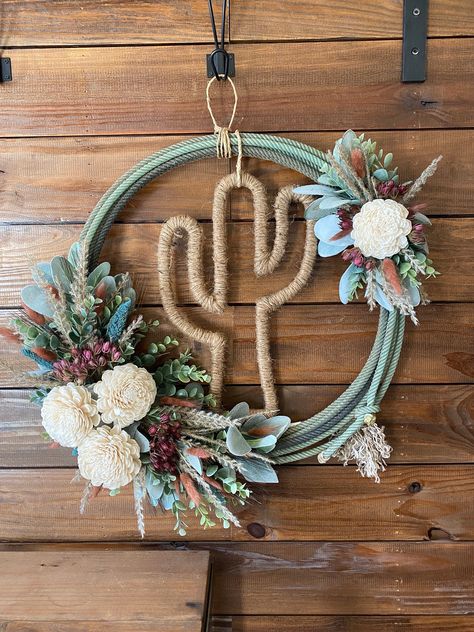 We all have a story about how our business's got started. Mine to be exact describes my whole business.. A Ropers Wife.  This wreath is made from a slightly used lariat rope. It is covered with a delicate touch of a floral arrangement that is attached directly to the rope. This floral arrangement includes pampas grass, sola flowers, wheat, lambs ear, eucalyptus, mauve lagurus stems, burgundy seed pod pick, and turquoise/teal cattails. **This arrangement is assembled by hand, please expect each a Old Rope Wreath, Old Rope Ideas, Rope Wreaths Western, Western Rope Decor, Lasso Rope Wreath, Western Rope Wreath, Diy Western Crafts, Western Diy Decor Craft Ideas, Leather Wreath