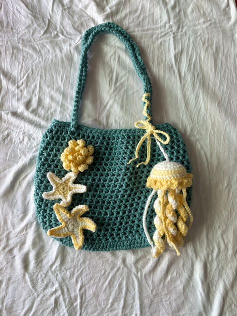 A beautiful tote bag with an ocean scene. Perfect for carrying your beach essentials or shopping. Made of durable cotton.#crochetkeychain #handmadegifts #DIYkeychain #crochetlove #keychainaddict Crochet Ideas Pictures, Crochet Projects Thick Yarn, Ocean Crochet Ideas, Crochet Ocean Bag, Crochet Bag Accessories, Starfish Crochet, Ocean Crochet, Sea Crochet, Crochet Ocean