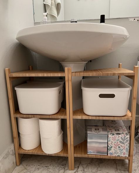 Two bamboo IKEA RAGRUNDS stocked with bathroom supplies under a pedestal sink Wall Mount Sink Storage, Cabinet For Under Sink, Diy Undersink Cabinet, Diy Bath Table, Floating Sink Storage Ideas, Toothbrush Storage Pedestal Sink, No Bathroom Storage Solutions, Cover Pedestal Sink, Bathroom No Cabinets Storage Ideas