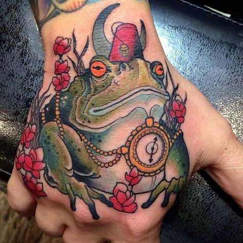 Hand tattoo of a bullfrog wearing a fez. So cool. Toad And Frog, Traditional Hand Tattoo, Traditional Tattoo Old School, Hand Tats, Frog Tattoos, Facial Tattoos, Koi Fish Tattoo, Chest Piece Tattoos, Irezumi Tattoos