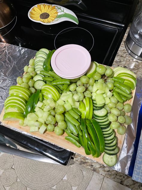 Fruits, veggies and guacamole in the container All Green Veggie Tray, Green Christmas Charcuterie Board, Green Picnic Food, Green Food Charcuterie Board, Green Colored Snacks, Green Color Foods For Party, Green Theme Food Ideas, Green Food Platter, Green Themed Charcuterie Board