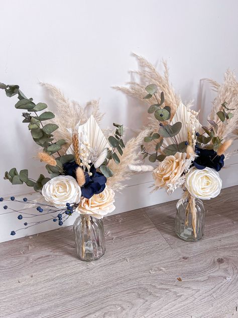 Small vase centrepieces consisting of dried, preserved and artificial flowers. The perfect keepsake from your wedding day and also great gifts for your wedding party! These are totally customisable so if you're looking for a different colour from the main listing (navy blue and sage) please write in the personalisation box 😊 The size of the vase is 14x7.5cm and the total size of the vase and florals is around 40x25cm (sizes may vary). Please note, the price is for one vase centrepiece. For more designs please follow me on Instagram - boho_backdrops Thank you. Kerris x Blue Eucalyptus Wedding Centerpiece, Navy Blue Flower Arrangements Table Settings, Simple Cheap Centerpieces Wedding, Rustic Wedding Decor Navy Blue, Blue Eucalyptus Centerpiece, Navy Blue Wedding Centerpieces Diy, Navy Blue Table Decorations, Wedding Beach Centerpieces, Blue Fall Wedding Centerpieces