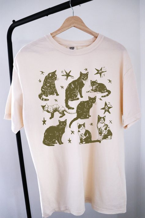 Vintage 90s Tattoo Cat Tshirt ⭐ Welcome to K & K Custom Tees! ⭐  - Indulge in pure comfort with our Comfort Colors Shirt. Soft, relaxed, and available in a variety of colors! ⭐SHIRT DETAILS⭐  -High Quality fabric  -100% ring-spun US cotton -Designed and printed in the USA  ⭐ PLEASE NOTE ⭐ -For an oversized look, we suggest to size up 1-2 sizes. These shirts run like standard unisex tees. Please see size chart for a more fitted look!  -Colors may vary based on your monitor or screen display! ⭐CARE INSTRUCTIONS ⭐ -Machine wash inside out in cold water  -Tumble dry medium or hang to dry  -Do not dry clean or iron directly onto the design  ⭐PROCESSING & SHIPPING TIMES ⭐ -Processing time: 3 to 5 business days  -Shipping time: US - 2 to 5 business days  ⭐OUR GOAL⭐  -Delivering top-notch t-shirts San Jose, Graphic Tees 90s, Retro T Shirt Designs, Cool Shirt Designs Graphic Tees, 90s T Shirts, Vintage Graphic Shirt, Cat Tshirt Design, 90s Tattoos, Vintage Tshirt Design