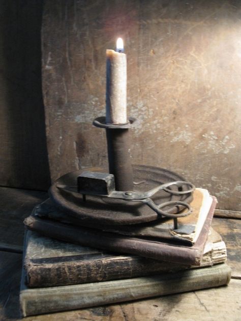 A stack of old readers, and the candle to read by. Old Candle Aesthetic, Medieval Candle, Ancient Candle Holder, Country Lighting, 1803 Candles, Antique Cast Iron Candle Holder, Primitive Lighting, Primitive Design, Old Candles