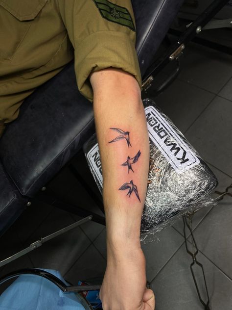 A Tattoo of 3 swallows on a soldiers arm Birds Around Arm Tattoo, 3 Birds Tattoo Men, Men Bird Tattoo Arm, 3 Swallow Bird Tattoo, Bird On Forearm Tattoo, Sparrow Tattoo Forearm, Mens Sparrow Tattoo, Birds Flying Up Arm Tattoo, Small Bird Tattoo Men Arm