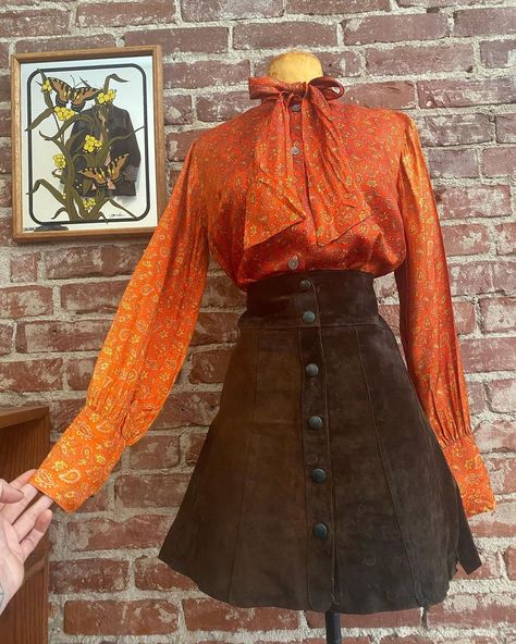 Look on Instagram: “Skirt is *Sold* 70s poet sleeve paisley tangerine blouse paired with a delicious 70s dark chocolate suede snap button skirt. Yum. Link in…” 70s Shirt Outfit, 70s Two Piece Outfit, Orange 70s Outfit, 70s Denim Skirt, Dark 70s Outfits, 70s Skirt Outfit, Skirt And Blouse Outfit, 70s Skirts, Vintage Clothes 70s