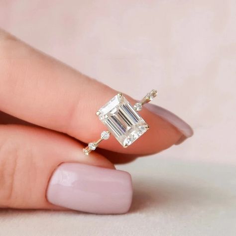 Delicate 1.75 CT Emerald Cut Solitaire/14k Solid Yellow Gold Ring/Wedding Promise Ring/Floating Round Cut Accents/Trends Setter/Gift For Her ❤ ITEM DETAILS:- ✦ Brand: The American Gold House (TAGH) ✦ Handmade, high-quality item! ✦ Material: Solid 10K/14K/18K Gold, 950 Platinum and 925 Sterling Silver ✦ Diamond Type: Moissanite Diamond ✦ Diamond Cut: 8x6 MM Emerald ✦ Diamond Weight: 1.75 CT ✦ Main Stone Color: Colorless ✦ Width of Band: 1.6 MM (Bottom) ✦ Diamond Clarity: VVS/VS ❤ ACCENT/HALO DIAMONDS:- ✦ Side Stone Material: Moissanite Diamond ✦ Side Stone Shape: Round Cut ✦ Side Stone Carat Weight: 0.18 CT ✦ Side Stone Color: Colorless ✦ Diamond Clarity: VVS/VS ------------------------------------------------------------------------------ 💎 Moissanite VS Diamond 💎 ----------------------- Emerald Cut Moissanite Engagement Ring, Emerald Cut Engagement, Minimalist Engagement Ring, Moissanite Engagement Ring Solitaire, Emerald Cut Moissanite, Emerald Engagement Ring Cut, White Gold Wedding Rings, Dream Engagement Rings, Emerald Engagement