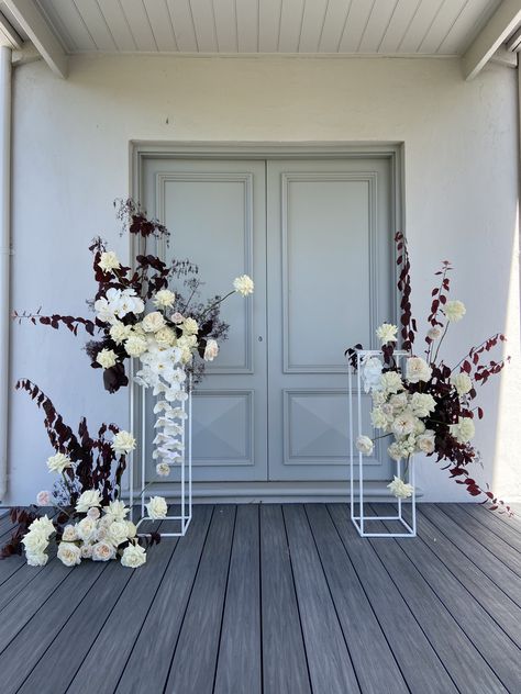 modern white florals plinth arrangements featuring all of the best - orchids, flexed roses, burgundy smoke bush foliage and more Plinth Arrangements Wedding, Plinth Ceremony Flowers, Plinth Flower Arrangement, Flowers On Plinths, White Flower Installation, Floral Plinths, Rustic Arbour, Contemporary Wedding Flowers, Boutique Flowers