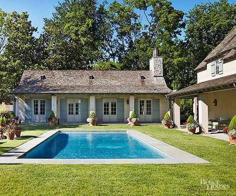 Take inspiration from your home's architecture when designing a backyard pool. Here, a plainly profiled pool with a limestone-tiled deck sits amid a clipped lawn and reflects a country French attitude that echoes the architectural style of the home. The pool deck visually references vertical columns that support a roof that shades a patio area connecting to the home and guesthouse. Hamptons Pool, Country Pool, Paved Patio, Dream Pools, Backyard Pool Designs, Outdoor Entertaining Area, Inviting Home, French Country Style, Pool Patio