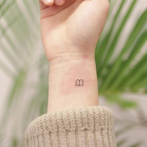 Book Tok Tattoo, Tiny Book Tatoos, Bookish Minimalist Tattoo, Minimalist Reader Tattoo, Book Stick And Poke Tattoo, Book Micro Tattoo, Small Teacher Tattoo Ideas, Small Book Related Tattoos, Tiny Book Tattoo Simple