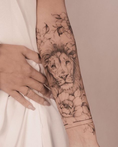 50 Eye-Catching Lion Tattoos That’ll Make You Want To Get Inked - KickAss Things Lion Arm Sleeve Tattoos For Women, Lion Tattoo With Flowers, Mutterschaft Tattoos, Lion Tattoo Ideas, Female Lion Tattoo, Lower Arm Tattoos, Wreath Tattoo, Lioness Tattoo, Lion Tattoo Sleeves