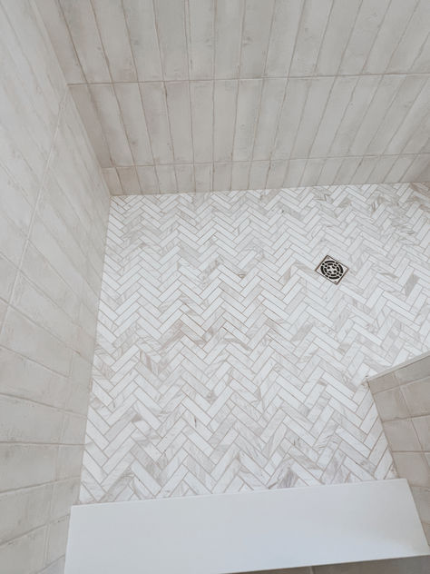 Master bath design. Shower tile. Bath tile. Herringbone tile. White tile bathroom. Walk in shower. Grey Herringbone Shower Floor, Master Shower Herringbone Tile, White Herringbone Shower Floor, Bathroom Shower Tile Ideas Walk In Herringbone Pattern, Primary Bathroom Shower Tile, Herringbone Tile Shower Floor, Shower Tile Herringbone, Bathroom Floor And Shower Tile Matching, White Herringbone Shower Tile