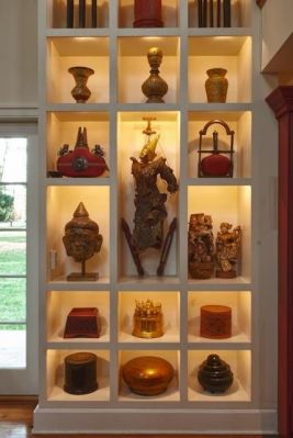 Custom-built boxes display lacquer pieces from Burma and China as well as 19th century Indian water bottles, a Burmese puppet and a Thai Buddha head. Buddha Statue Under Staircase, Buddha Shrine Room Design, Home Entrance Budha, Modern Buddhist Altar, Buddha Statue Shelf, Townhouse Apartments, Asian Interior Design, Asian Sculptures, Meditation Room Decor