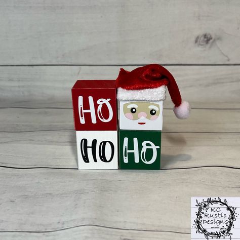 "These HO HO HO Santa inspired wood blocks will add a nice touch to your Christmas decor. They will also look cute standing alone or in your tier tray!  The blocks are hand painted. They are then sanded to achieve that rustic state. I then affixed high quality vinyl for all wording and designs. They are sprayed with a sealant for longevity.  My items are all handmade, no two pieces are alike. Each piece has its own natural imperfections which make them unique.  The blocks standing on each other Tier Tray Wood Blocks, Christmas Scrap Wood Crafts, Christmas Wood Blocks Diy, Wood Block Crafts Christmas, 4x4 Christmas Wood Crafts, Christmas Blocks Wooden Diy, Wooden Cube Crafts, Wooden Blocks Decor Craft Ideas, Christmas Craft Fair Ideas To Sell