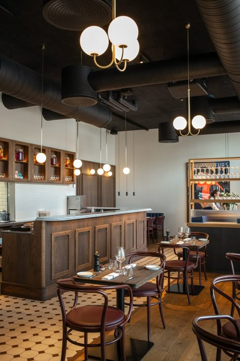 Bistro Le Bleu in Aarhus, Denmark has an airy and light interior design with large windows and a high ceiling. To ensure the bistro’s good acoustic qualities, black Troldtekt acoustic panels were chosen for the entire ceiling to camouflage the black-painted ventilation pipes and similar installations. #goodacoustics #holzwolleplatten #träullsplattor #woodwoolpanels #troldtekt | Architects: SLETH French Bistro Restaurant Interior, French Bistro Interior, French Cafe Interior Design, Cafe Stairs, Modern French Bistro, French Bistro Decor, Bistro Interior Design, Italian Coffee Shop, Dark Wooden Furniture