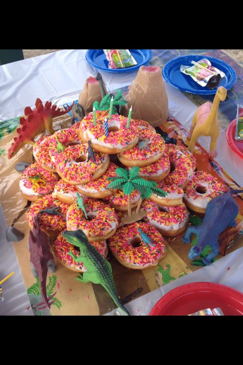 Super easy and fun dinosaur donut birthday "cake" Birthday Cake Dinosaur, Donut Birthday Cake, Girl Dinosaur Birthday, Dinosaur Themed Birthday Party, Donut Birthday Parties, Dino Birthday Party, Donut Birthday, Dinosaur Theme Party, Dinosaur Cake