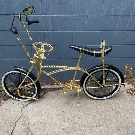 Gold twisted frame, flat twisted handlebars, flat twisted bent springer fork, flat twisted flared sissy bar, twisted pedals, black 20” wheels, black fenders, low rider 20” tires, gold chain link steering wheel. $1000 Low Rider Bike, Low Rider Bike Bicycles, Lowrider Bikes, Rider Bike, Lowrider Bicycle, Bicycle Tattoo, Beach Cruiser Bikes, 20 Wheels, Lowrider Bike