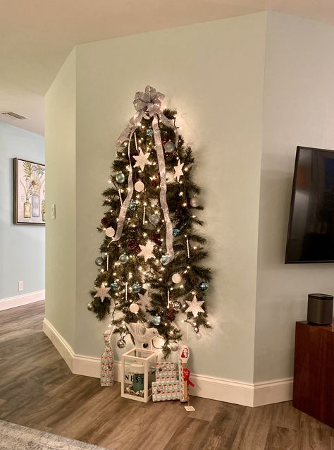 Wall Christmas Tree- when you don’t have room for a full tree! Fold two strings of garland in half and flatten the branches on one side. Hang both on the wall on command hooks - one a few inches lower than the other. Secure the 4 end pieces to the wall with non damaging tape. Decorate as usual. Diy Wall Christmas Tree, Small Space Christmas Tree, Wall Mounted Christmas Tree, Christmas Tree Gif, Half Christmas Tree, Half Christmas, Wall Hanging Christmas Tree, Christmas Tree Clear Lights, Cardboard Christmas Tree