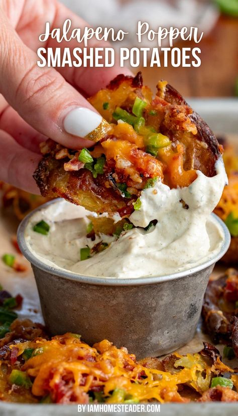 A hand is holding a smashed potato and dipping it into a creamy sauce in a silver cup. There are other smashed potatoes around it on parchment paper. Jalapeño Popper Smashed Potatoes, Jalapeño Mashed Potatoes, Side Dish For Friendsgiving, Jalapeño Popper And Potato Chowder, Food Truck Potatoes, Get Together Side Dishes, Football Season Dinners, Jalapeno Popper Baked Potato, Smashed Potato Skins