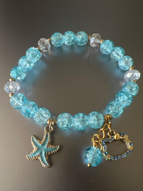 Item Details: 1 PC Blue Round Acrylic Crystal Beads Bracelet with Kitty and Starfish  Charm Quantity:  Selling 1 piece Material:  Acrylic Color(s): Blue crystal as the picture shown Bead Size:  8mm Bracelet Size: 16cm (adjustable).  Closure: The beads are strung with an elastic spool to fit most sizes.   Bead Shape:  Round NOTE:  -  The variance and colors you see on your screen may not be the exact color of the gems in person.   -  Due to the unique nature of the stones, all colors, sizes, and shapes may vary. - Inclusions are natural impurities found in the gemstones and develop while the stone is being processed in nature's womb - Certain types of inclusions are found more often in natural gemstones than in their synthetic counterparts -  Needles, clouds, fluids, crystals, and materials Blue Handmade Bracelet, Cute Blue Bracelet, Crystal Bead Jewelry Ideas, Unique Bracelet Ideas, Braslet Ideas Cute, Crystal Bead Bracelet Ideas, Stone Bracelet Ideas, Gem Bracelets, Stone Bead Bracelets