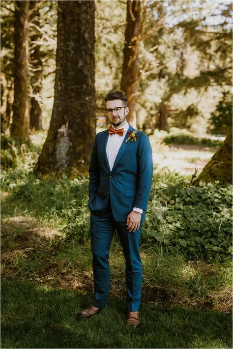 A teal Indochino suit with a burnt orange bowtie at this Oregon Coast wedding. #groom #tealsuit #groomattire #indochino Orange Outfits Men, Burnt Orange Outfits, Burnt Orange And Teal Wedding, Teal Groomsmen, Teal Wedding Ideas, Indochino Suit, Orange And Teal Wedding, Fall Wedding Tuxedos, Country Wedding Groomsmen