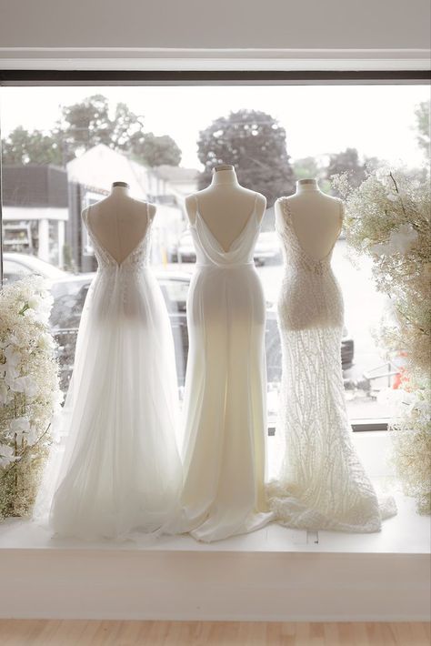 Window display taken from inside, with three mannequins facing towards the street. The mannequins are wearing three different white wedding gowns and they are surrounded by white florals. With Love Bridal Boutique Ottawa, Bridal Shop Window Display, Bridal Window Display, Revelle Bridal, Luxurious Dress, Shop Inspiration, Ottawa Wedding, Wedding Dress Shop, Luxurious Dresses