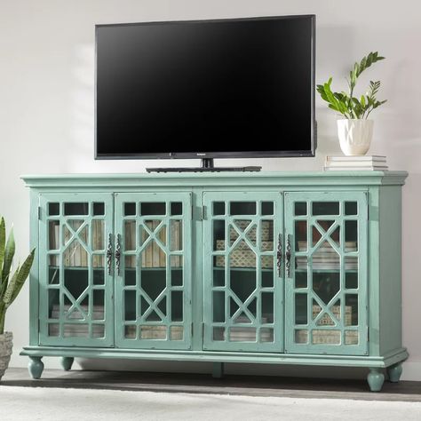 Mistana™ Ira TV Stand for TVs up to 78" & Reviews | Wayfair Teal Tv Stand, Glass Tv Stand, Dining Room Server, Flat Panel Tv, Tempered Glass Door, Trellis Design, Tv Stand Wood, Tv Stands And Entertainment Centers, Distressed Painting