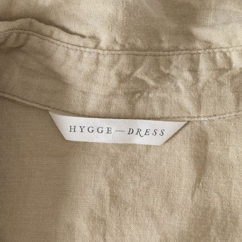 Logo that says Hygge Dress on a white label inside a shirt Dress Labels, Branding Label Design, Labels For Clothing, Clothing Label Inspiration, Label On Clothes, Lables Idea Clothing, Clothing Label Design Ideas Branding, Linen Branding, Brand Label Clothing