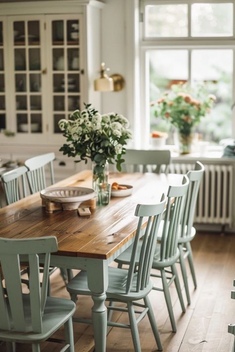 Discover timeless farmhouse dining room decor ideas that blend rustic charm with cozy sophistication for your welcoming space. Get inspired now! Big Farmhouse Dining Table, Farmhouse Home Aesthetic, Blue Chairs Dining Table, Cozy Modern Farmhouse Dining Room, Cottage Farmhouse Dining Room, Green Farmhouse Dining Room, Coastal Farmhouse Dining Room Ideas, Dining Room Cottagecore, Small Cottage Dining Room