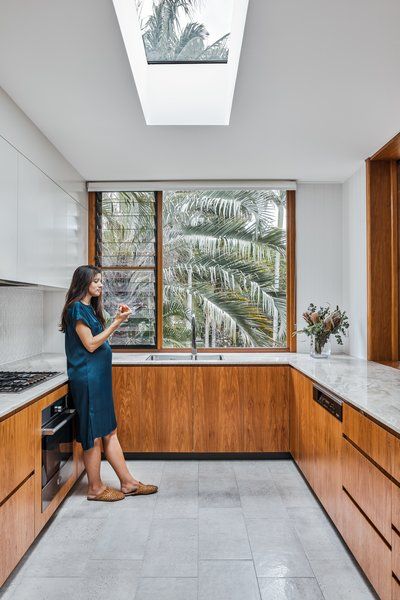 Louvered windows in the kitchen and bathroom provide natural ventilation. The floor and countertop have a natural, organic texture to them that ensures the space feels homey and modern rather than cold and clinical. Louvered Windows, Contemporary Window, Modern Window Design, Kitchen Window Design, Louvre Windows, Louver Windows, Street House, Grill Design, Kitchen Photos