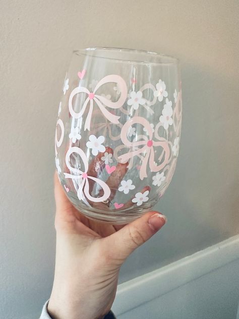 Coquette Wine Glass- Daises- Pink Bows- Gift for Her- Pink Wine Glass- Love- Wine Tumbler- Heart- Wine Gift- Wine - Stemless Wine Glass This 21oz. stemless wine glass is the perfect girly gift! They will be pouring their wine in their new favorite glass! The wording is made from permanent, high quality vinyl.   *Care Instructions- Please hand wash item and DO NOT soak in hot water. DO NOT place in dishwasher. To ensure longevity softly hand wash without scrubbing Bow Wine Glass Painting, Wine Glass Engraving, Wine Glasses Painting Christmas, Wine Glasses Painting Ideas, Drawing On Glass Ideas Easy, Pretty Wine Glasses, Painted Glass Mugs, Cute Painted Wine Glasses, Wine Glass Designs Painted