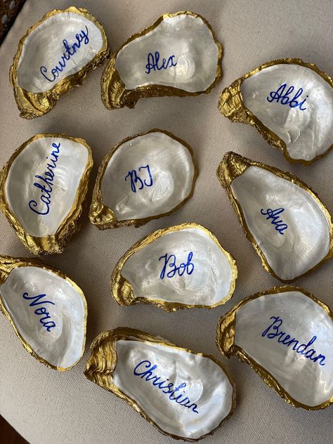 Personalised Beach style wedding favors, hand painted pearl with golden edge and dark blue ink names. Please send me a list of names to messages after placing an order. Feel free to message me to adjust number of shells needed or if you have any questions or concerns about your order. Each shell is unique as nature and has approximate length of 3.5-4 inches. Back of the shell is plain, not gilded.  Each shell is nicely packed with an organza bag to be delivered to your wedding. Oyster Place Cards, Shell Name Cards Wedding, Classy Beach Wedding Decor, Oyster Place Cards Weddings, Oyster Shell Seating Chart, Greek Beach Wedding, Small Details For Wedding, Dark Beach Wedding, Vintage Wedding Details