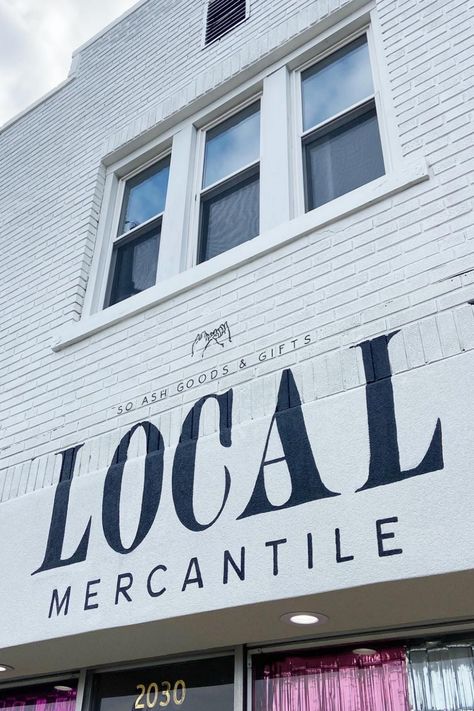 White painted brick building with a custom sign painting for Local Mercantile, a gift shop in Ashland, Kentucky. The sign features the store's name and logo painted in black lettering by The Tipton Creative. Business Exterior Design, Painted Brick Store Fronts, Storefront Curb Appeal, Small Business Signage, Diy Store Sign, Gift Shop Signage, Mercantile Logo, Boutique Signs Ideas Store Fronts, Print Shop Branding