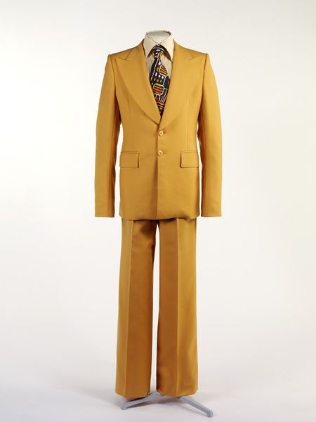 Man's suit | Victor Herbert | Great Britain, United Kingdom, 1974 | Material: wool | Herbert uses traditional tailoring techniques combined with flamboyant details of cut and colour typical of 1970's British menswear | VA Museum, London 70’s Mens Fashion, Colourful Suit, 70s Fits, 70s Suit, Theater Poster, Retro Suits, 70s Men, Fashion 1970s, Yellow Suit