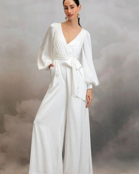 MIA JUMPSUIT by @catherine__deane — The Mia Jumpsuit is cut from luxurious eco satin. This classic bridal jumpsuit features a crossover, low V-front neckline, low V-back and long bishop sleeves with statement cuffs. Mia’s detachable waist sash cinches in the small of the waist for a figure flattering silhouette and her comfortable, wide leg trousers will see you dancing the night away in effortless ease! #bridalwear #bridaljumpsuit #jumpsuit #civilwedding #civilweddingdress #standesamt #we... Designer Overalls, Vietnam Clothes, Unusual Wedding Dresses, Catherine Deane, Wedding Dress Types, Bridal Kimono, Sleeved Wedding, Cape Wedding Dress, Civil Wedding Dresses