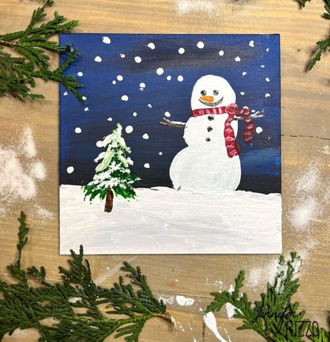 A painted snowman with a red scarf stands beside a small pine tree in a snowy scene, set against a dark blue sky with falling snowflakes. Fir branches frame the wooden surface. Easy Snowman Painting, Thrift Store Painting, Store Painting, Interior Design Crafts, Small Pine Trees, Dark Blue Paint, Dark Blue Sky, Painted Snowman, Christmas Open House