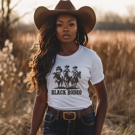 Dive into the essence of Western elegance with our 'Black Rodeo Unisex Tee,' a fashion statement that celebrates heritage and the adventurous spirit of three stunning Black women on their majestic rides. Perfect for individuals passionate about Western equestrian culture, heartland melodies, and the vibrant traditions of rodeo, this tee is a tribute to the enduring strength of cowgirl legends. Crafted from premium soft materials for ultimate comfort and durability, it's ideal for any setting, from country outings to casual gatherings. Offering a range of sizes to ensure a perfect fit for everyone, this versatile tee bridges modern fashion with traditional homage, making it a must-have for those who cherish the legacy of Black cowgirls and the timeless charm of Western culture, all while em Black Cowgirl Photoshoot Ideas, Rodeo Outfits For Women Black, Plus Size Cowgirl Outfits Black Women, Country Outfit Black Women, Cowgirl Outfits Black Women Rodeo, Western Blazer Outfits For Women, Country Outfits Black Women, Black Cowgirl Outfits For Women, Cali Cowgirl