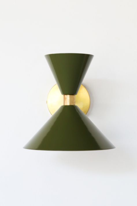 The Clancy sconce is a masculine hour-glass shaped sconce with two cones and a centered brass band. It has a single E26/medium base socket. The raw brass will develop a patina over time or can be polished occasionally to retain it's beautiful brassy sheen. We love this sconce used as a pair in a bathroom remodel, as bedside lighting, or in a long hall as accent lighting. The fixture can be installed with the large cone facing up or down. If you don't see the color you would like in the drop down Modern Glam Interior Design, Modern Glam Interior, Geometric Interior Design, Monochrome Interior Design, Living Room Sconces, Mid Century Modern Sconces, Geometric Interior, Bedroom Sconces, Glam Interior Design