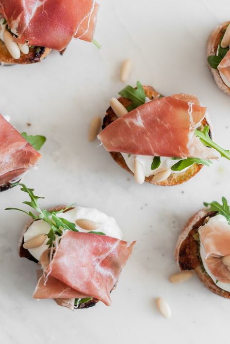 A simple combination of cheese, Parma Ham, rocket and pine nuts, these quick and easy crostini are a great option when serving up a selection of antipasti dishes. Seek out the best Parma Ham and buffalo stracciatella you can buy to make this recipe really stand out. Ham Crostini, Easy Crostini, Ham Appetizers, Burrata Recipe, Pine Nut Recipes, Crostini Recipe, Pickled Cherries, Come Dine With Me, Crostini Recipes