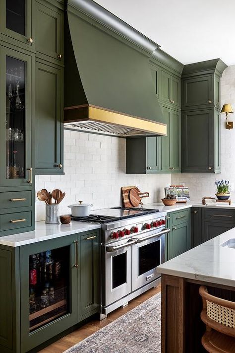 Kitchen features a green French range hood with brass trim over marble subway tiles and a Wolf dual range, green cabinets, a vintage runner and vintage wood and cane stools at a brown wooden island. Range Hood Ideas, French Range, Kitchen Hood Design, Hood Ideas, Renovated Kitchen, Washington Dc Metro, Green French, Green Kitchen Cabinets, Kitchen Range Hood